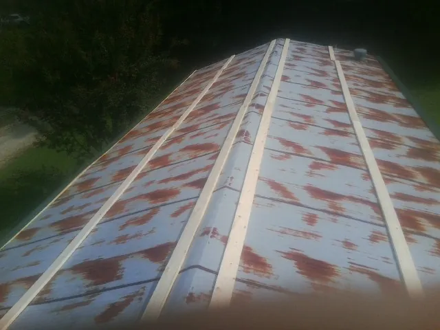 Rusted metal roof panels with new wood purlins before replacement — Storm Damage Roof Repair in Ormond Beach by Roofing Brothers